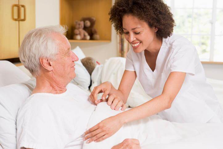 PSW helps a patient in bed 
