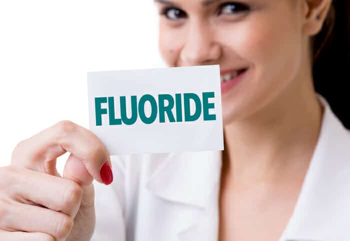 person holding a fluoride sign