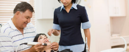 Dentist and assistant working on woman