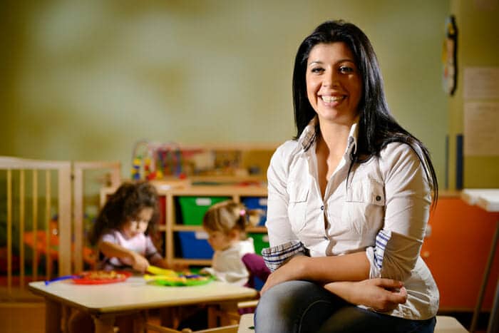 early childcare educator smiling in front of students