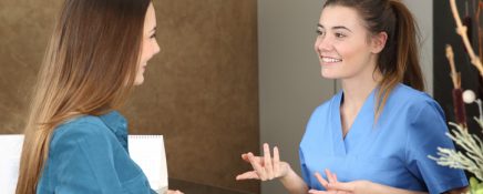 Happy dentist or nurse attending a patient in a consultation