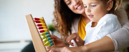 Mother and little cute girl, kid playing with abacus, early education