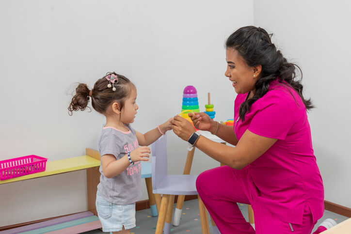 Caregiver interacting with a female child after Early Childcare Assistant Training
