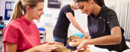 A massage therapist speaking to one of her students during Massage Therapy Training