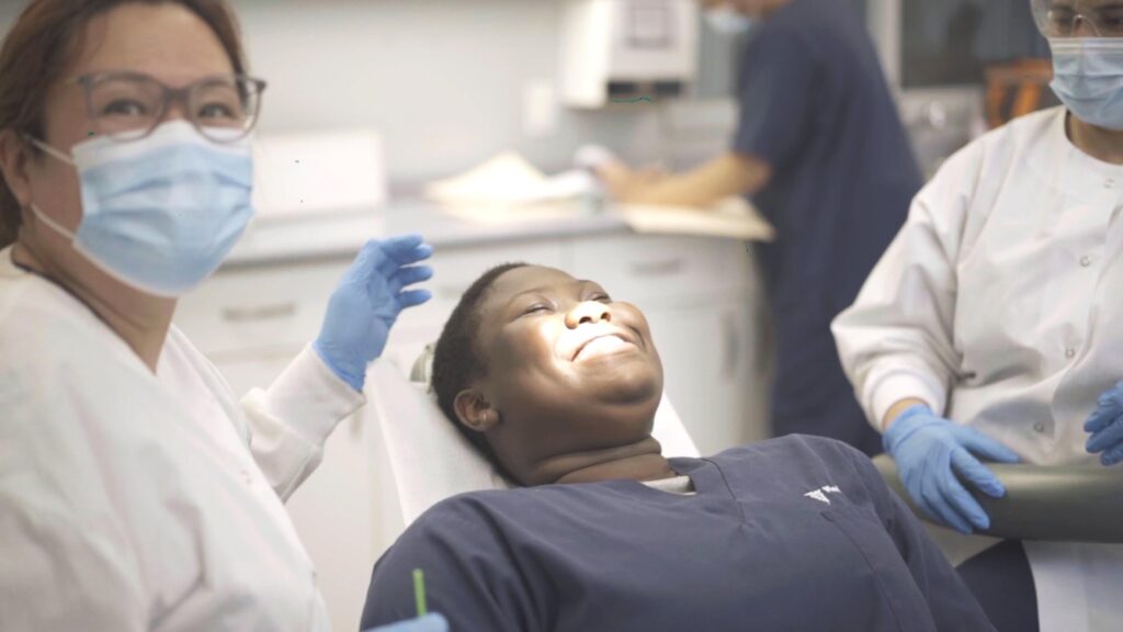  A dental assisting course graduate serving a patient chairside.