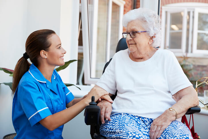A Medical Office Administrator assisting an elderly, exemplifying patient coordination, one of the many duties of a Medical Office Administrator