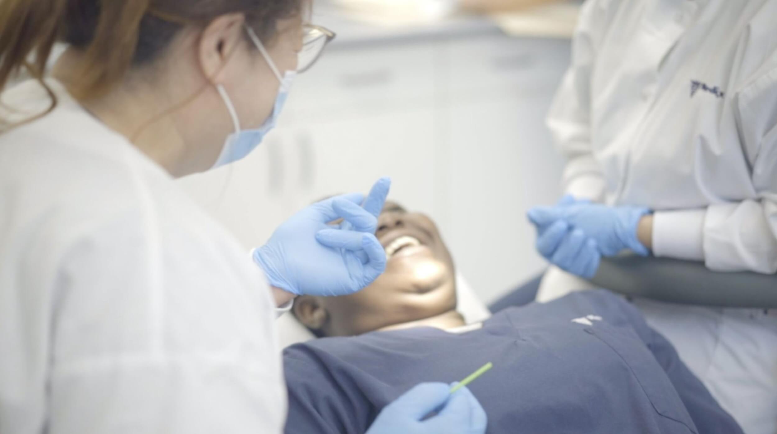 A student completing a dental assistant program in Toronto working on a patient
