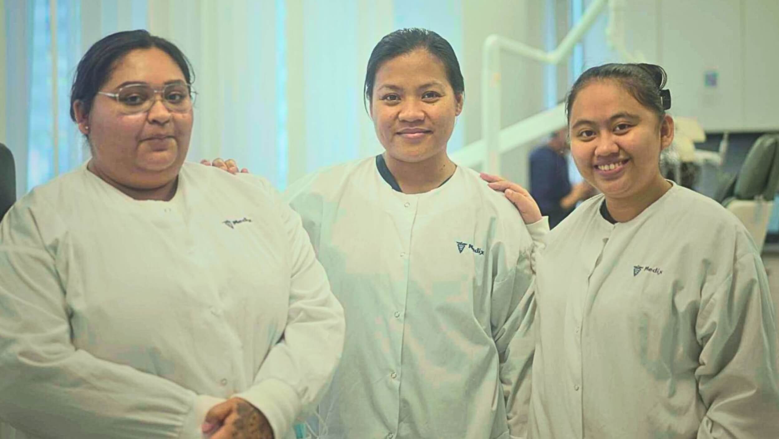 A trio of students completing a dental assistant program in Toronto posing together
