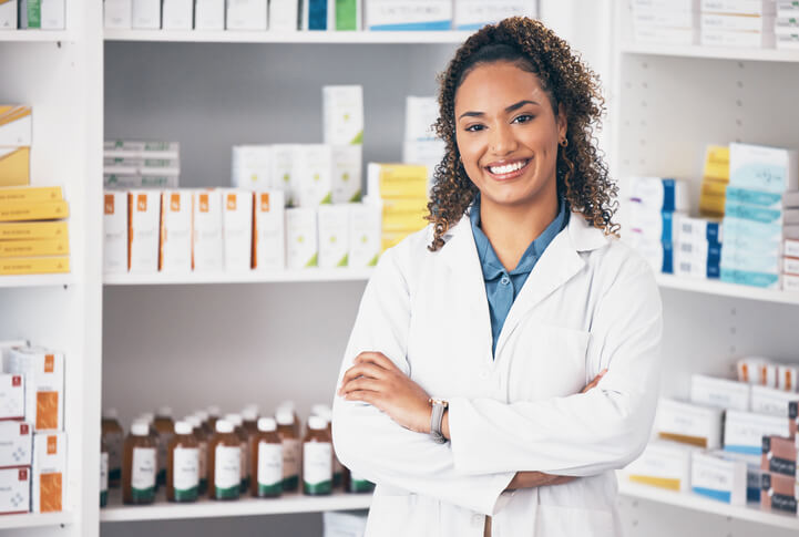 A Pharmacy Assistant course grad posing in a pharmacy