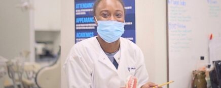 A smiling dental assistant at a clinic after completing her Dental Assistant Diploma.