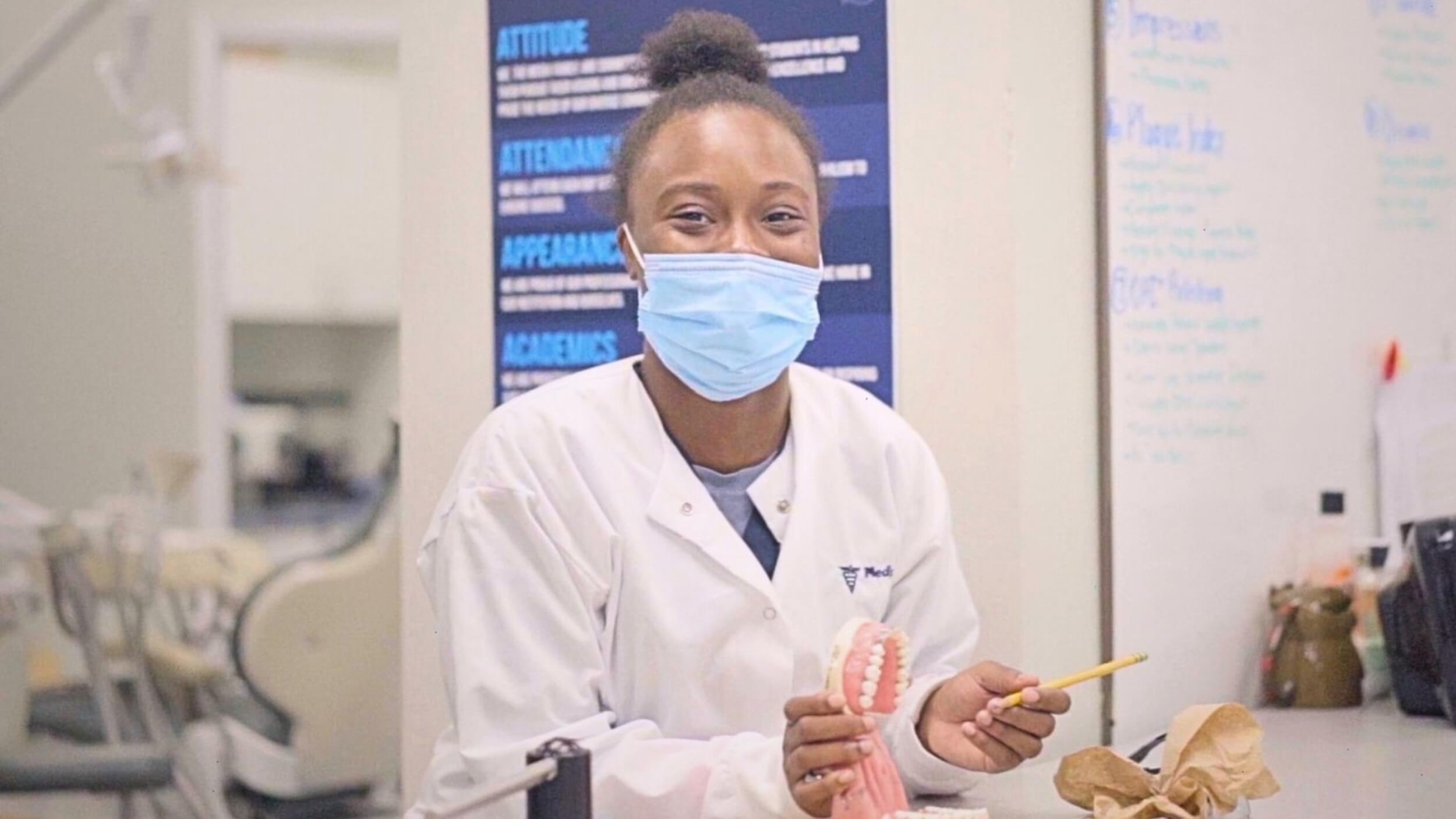 A smiling dental assistant at a clinic after completing her Dental Assistant Diploma.