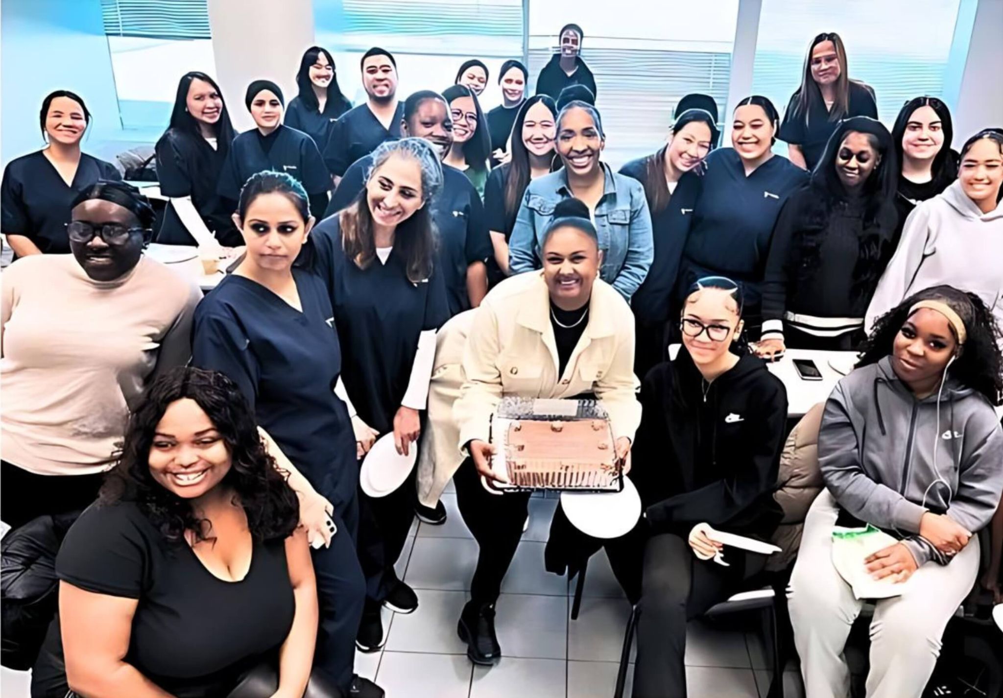 A group of Medix College students celebrating with a cake, highlighting the camaraderie in online and in-person classes.