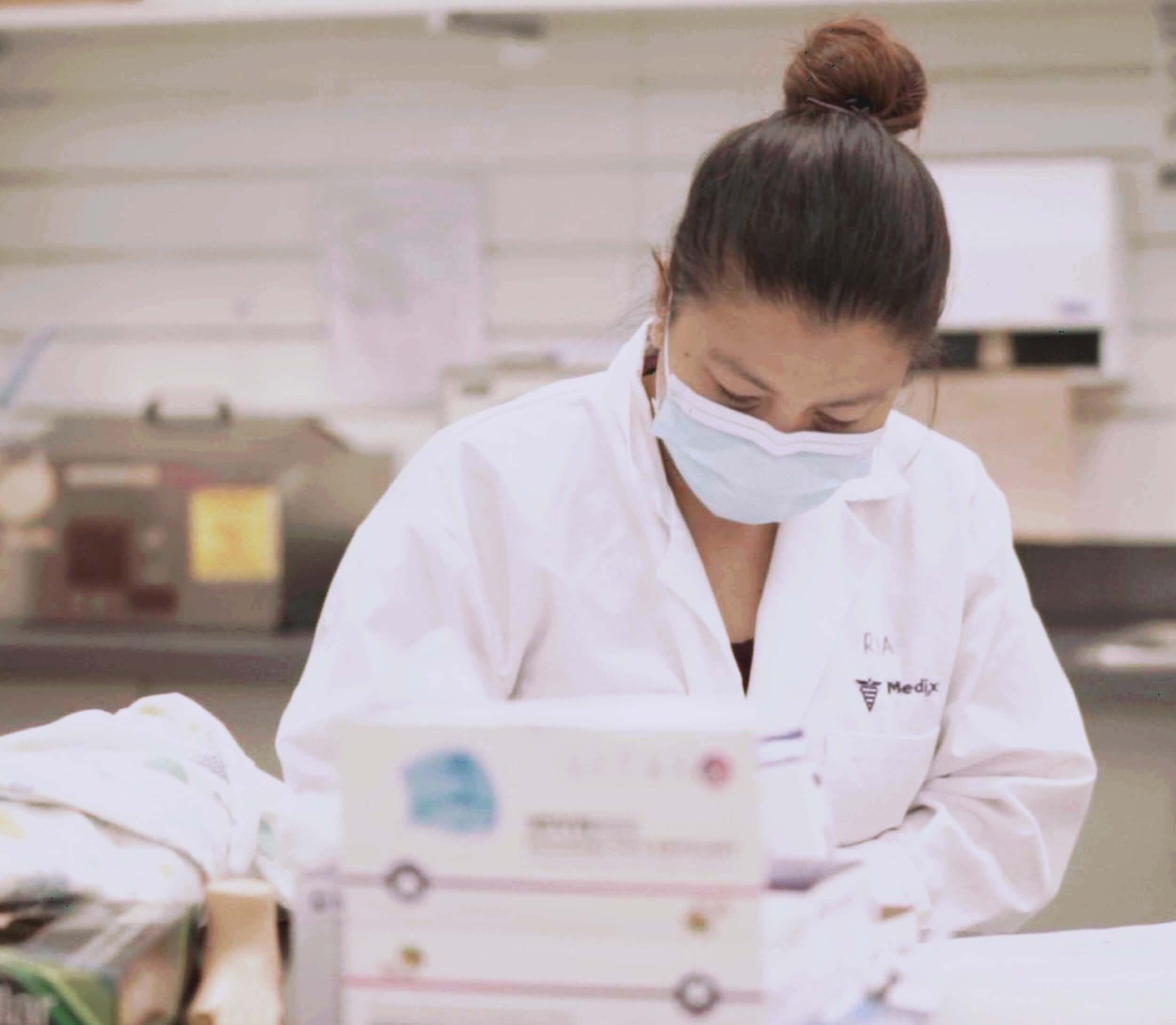 A focused female medical laboratory assistant performing her lab assistant duties