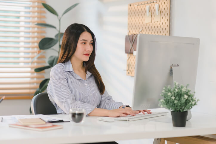 A female dental administrator checking patient records after completing her dental administration course