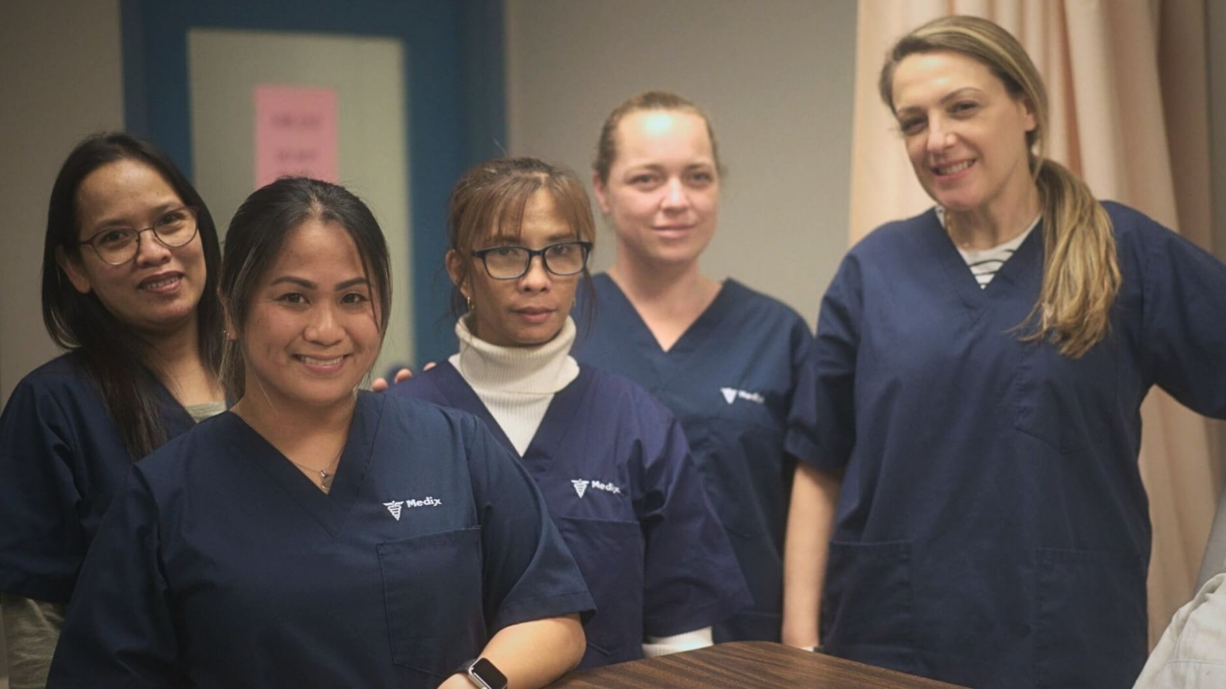 A group of five students learning PSW responsibilities posing together