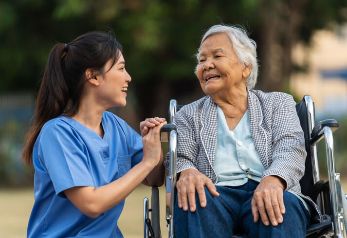 A female personal support worker helping an elderly female client with mobility