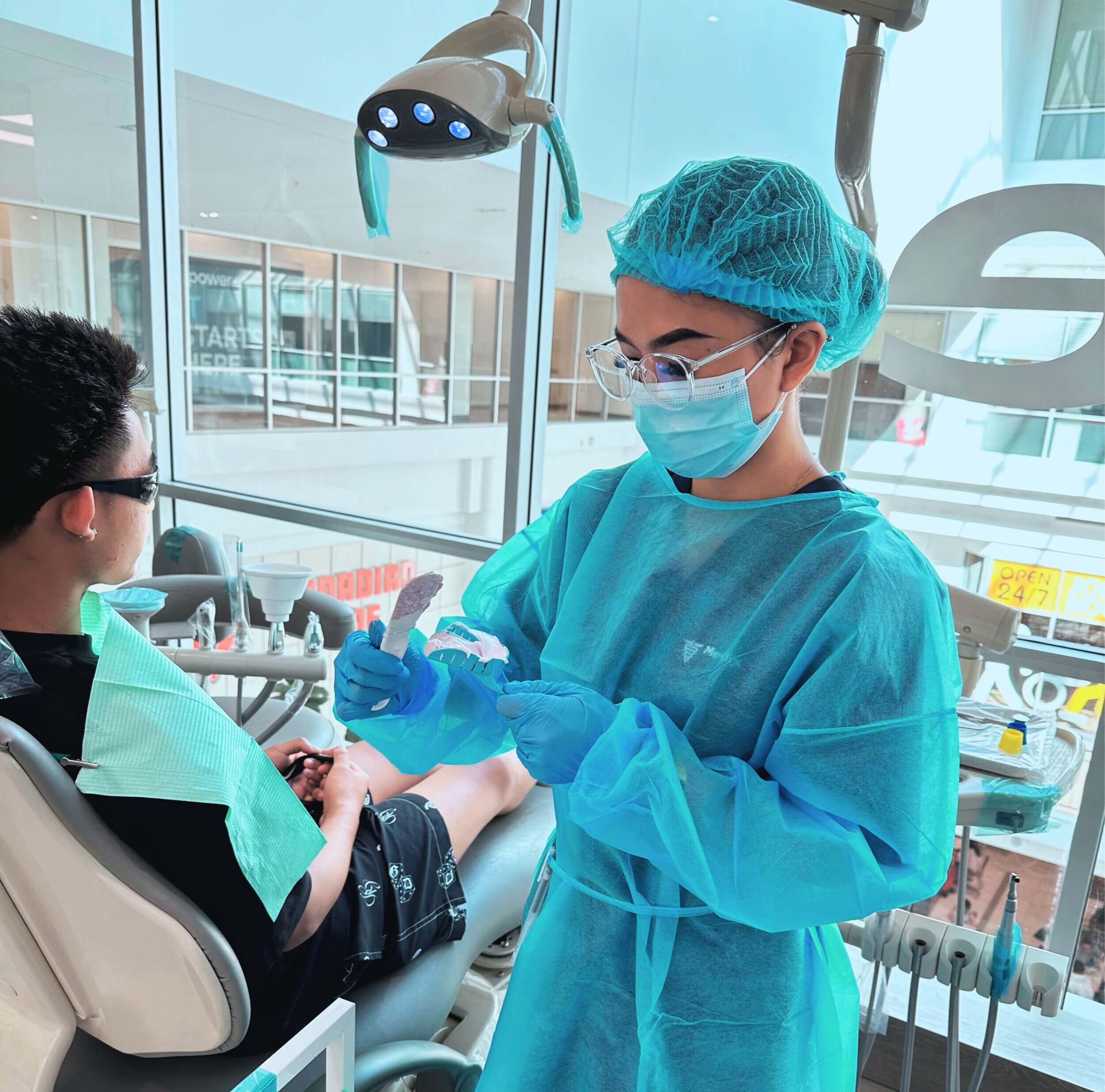 A dental student performs hands-on training with a patient, demonstrating practical skills in a clinical setting at Medix Career College.