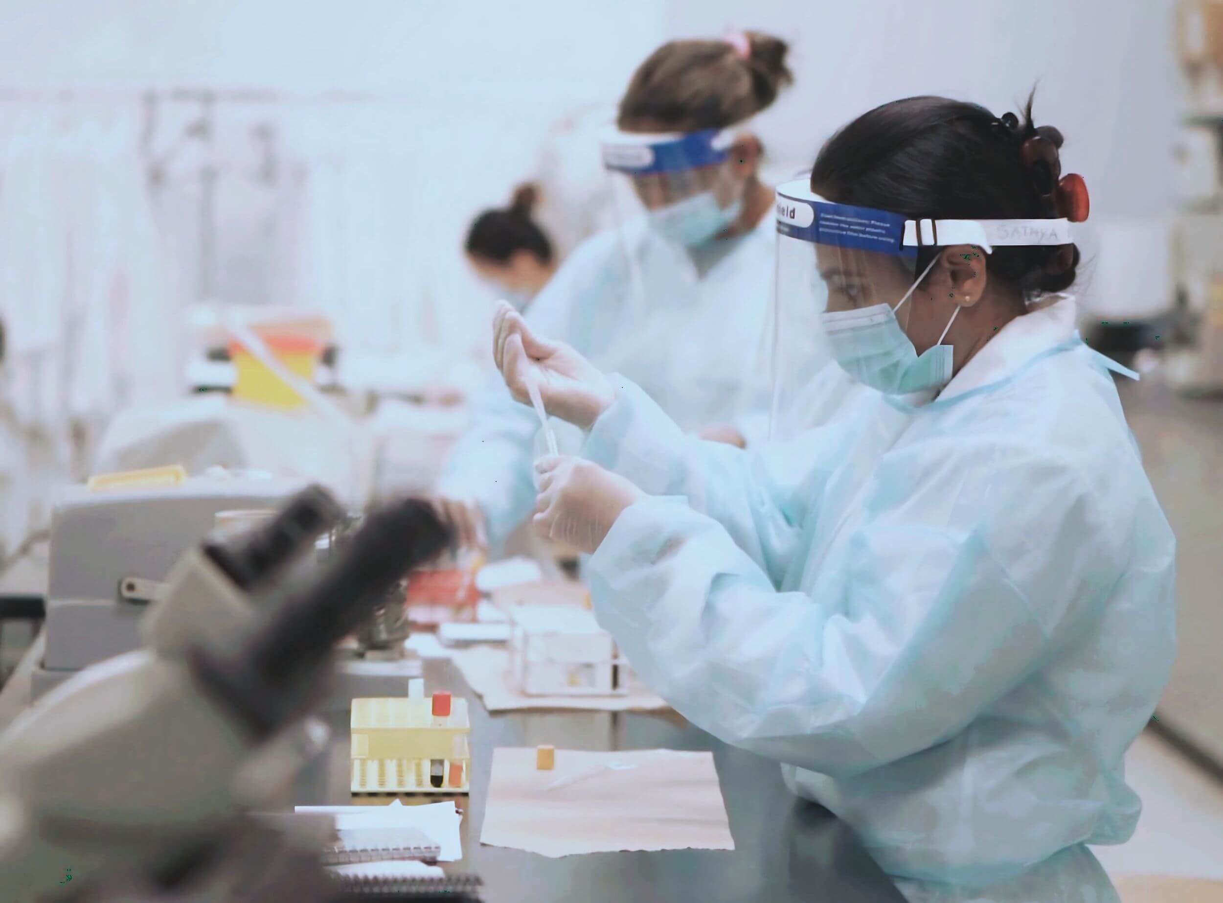 Students participate in hands-on training in a laboratory, handling samples with protective gear for real-world experience at Career College.