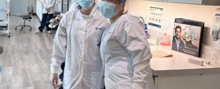 A pair of students from a Career College wearing masks and standing in a dental lab, ready for practical training.