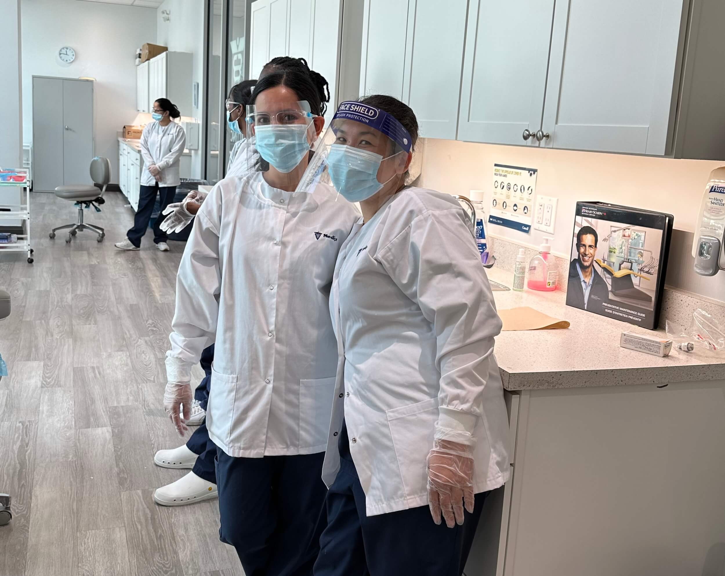 A pair of students from a Career College wearing masks and standing in a dental lab, ready for practical training.