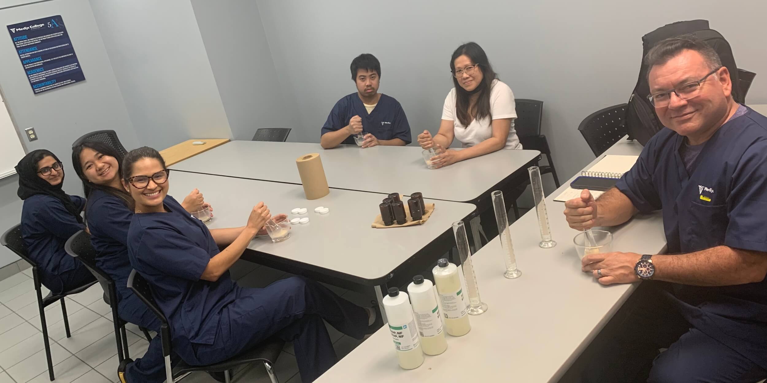 A group of students in the pharmacy assistant program completing a hands-on activity
