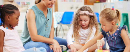 An early childhood assistant engaging children in a classroom activity
