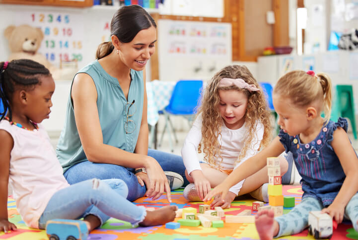 An early childhood assistant engaging children in a classroom activity