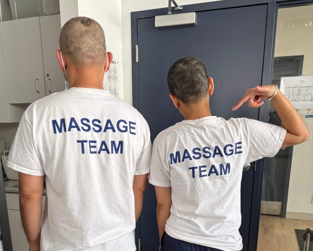 A pair of massage therapy students posing in their shirts