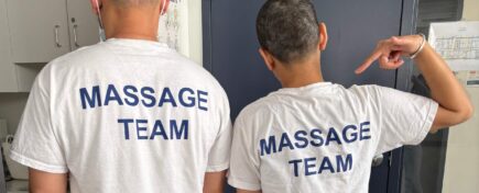 A pair of massage therapy students posing in their shirts